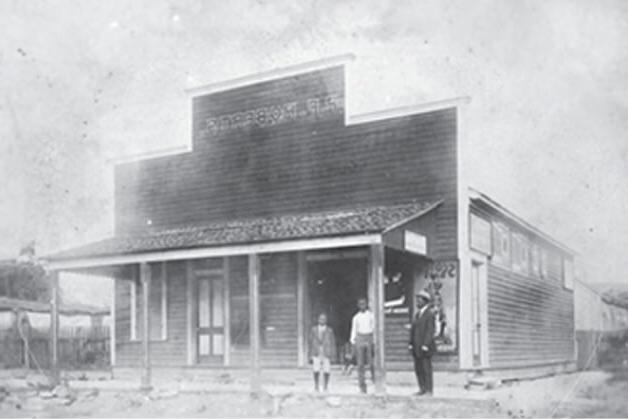 P.F. Roberts stands in front of his grocery store with family